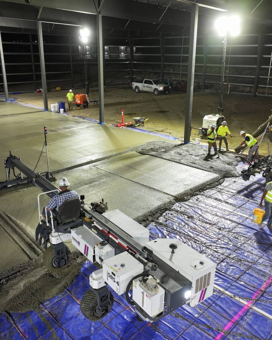 D&D Construction crew running a laser screed on a commercial concrete slab pour at night
