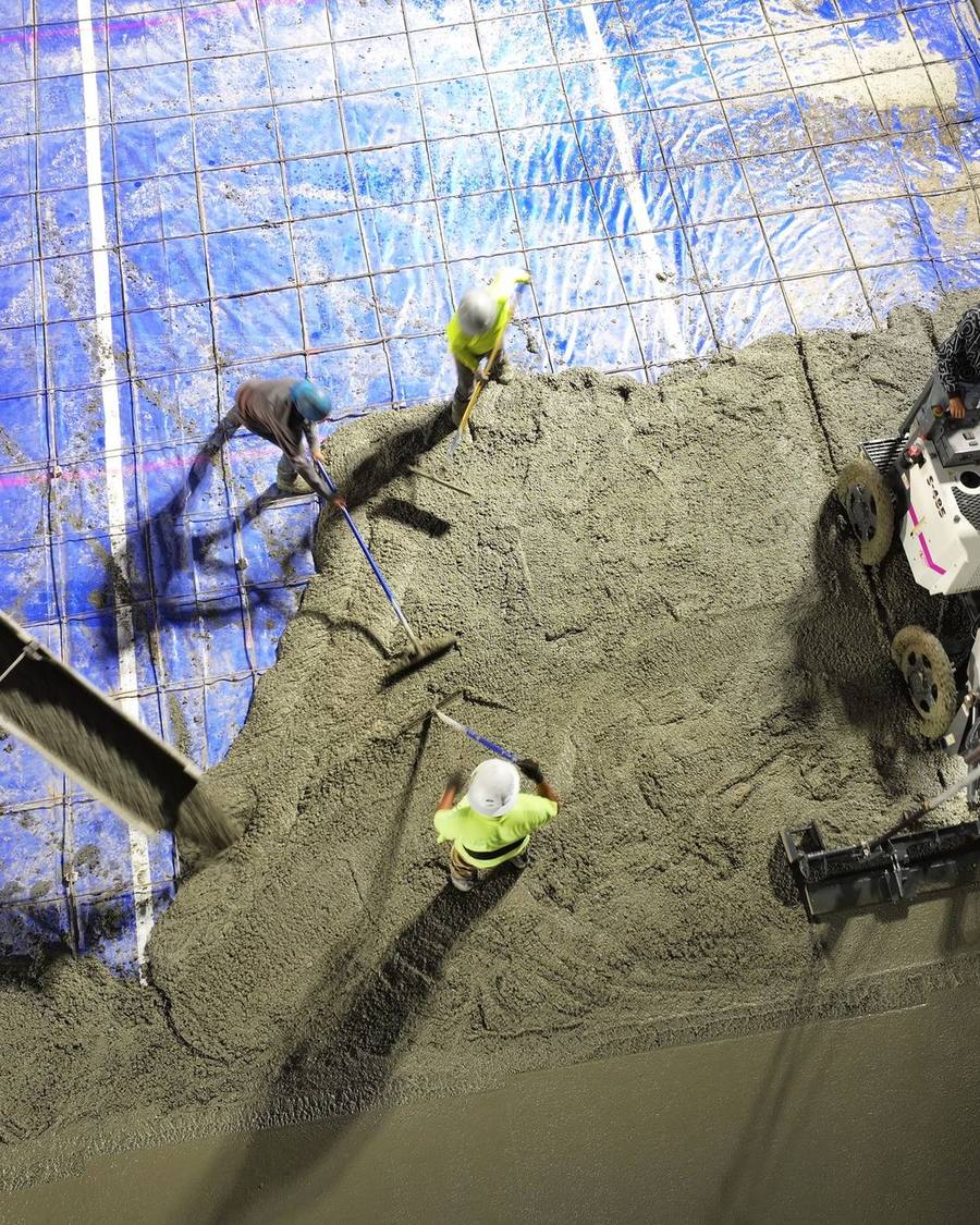 Overhead view of a D&D crew screeding and finishing a large freshly poured concrete slab